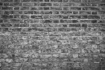 Head-on view of an old brick wall in monochrome.