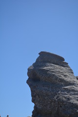 rock on background of blue sky sphinx romania