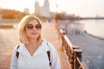 Obraz premium Outdoor portrait of happy young woman on city promenade.