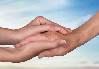Hands of man and woman holding together over background