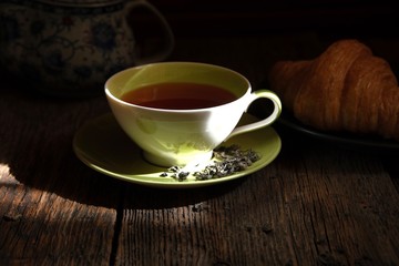 Tea composition. A Cup of aromatic tea on the background of an old wooden table.