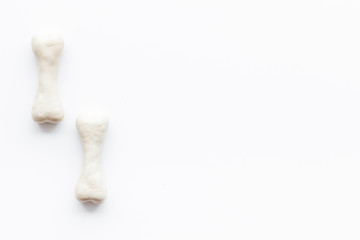 Food and toys for dogs. Chewing bones on white background top view copy space