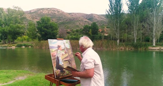 Anciano de pelo blanco pintando cuadro al oleo en rio oto&ntilde;o