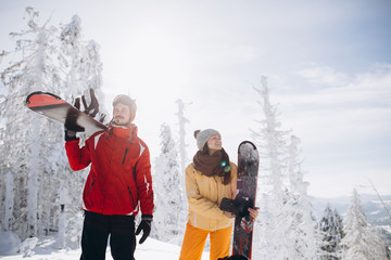 Happy couple having fun time with snowboards. Winter Sport