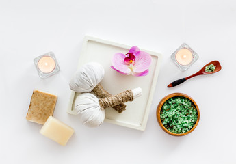 Preparing for massage in spa salon - with candles and orchids - white background top view