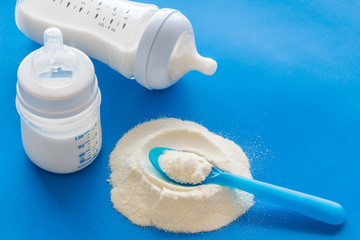 Powdered food for newborn baby near baby bottle on blue background copy space - Powered by Adobe