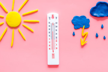Rainy weather. Thermometer near clouds and drops on pink background top view copy space