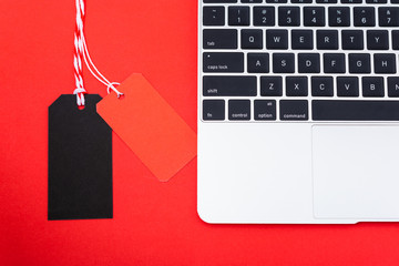 Internet online shopping marketing, top view of workspace with Blank red and black tags near laptop computer - Powered by Adobe