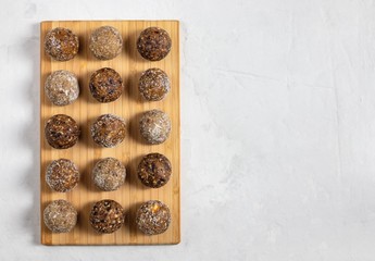 Homemade energy balls with dried apricots, raisins, dates, prunes, walnuts, almonds and coconut. Healthy sweet food. Copy space. Flat lay, top view