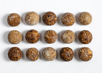 Homemade energy balls with dried apricots, raisins, dates, prunes, walnuts, almonds and coconut. Healthy sweet food. Energy balls on a white background