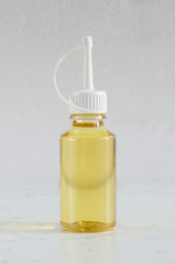 grease for accessories in a transparent bottle on a gray background.