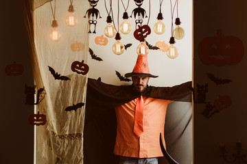 Funny wise wizard on a Halloween background. Handsome man in wizard costume hat for Halloween on...