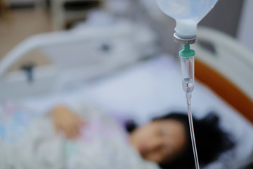 Woman sleep on bed and she is on a drip receiving a saline solution