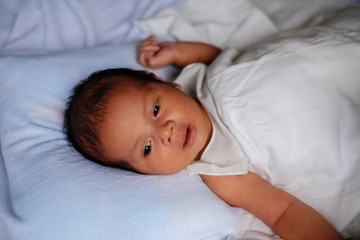 Newborn baby waking up and opening eyes.