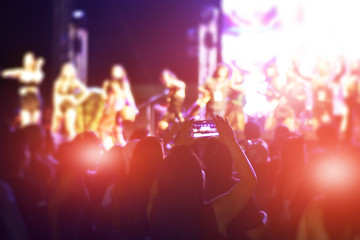 Fototapeta na wymiar Women using smartphone take a photo in concert,Happy new year party