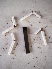 Vape pen electronic cigarette, as smoking alternative with broken cigarettes and scattered tobacco on white textured background