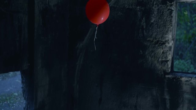 Red balloon flying in ancient stone building, symbol of dangerous trap, horror