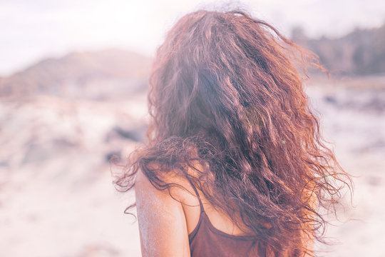close up portrait of young woman from the back outdoors at sunset