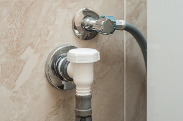 A way to connect a washing machine. Entrance of water drainage into the wall. Cold water outlet.