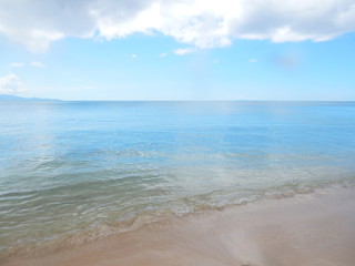 Une plage de sable blanc et la mer paradisiaque sous un ciel nuageux