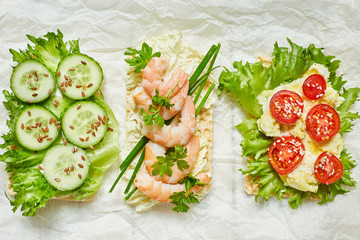 open sandwiches with freeze, tomatoes, cucumbers, shrimps, onions, parsley, flaxseed, sesame seeds