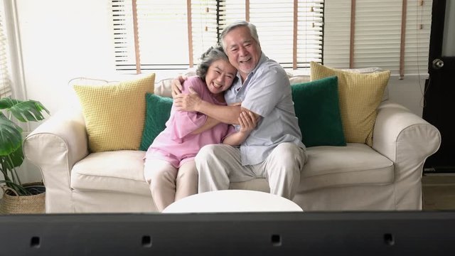 Senior couple watching movie emotion together in living room home theater at home. Concept of family, technology, entertainment and relax. 4k resolution.
