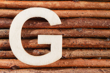 Letter G of wood-made alphabet, top view and space for text