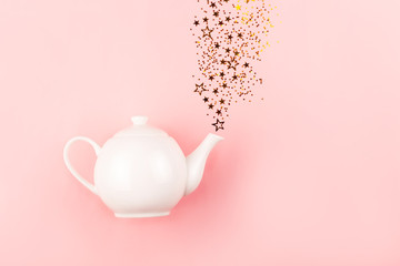 Creative shot of star shape confetti pouring from tea pot.
