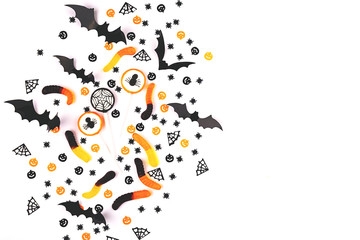 Halloween background made with candies, decoration and confetti.