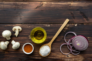 Close up pizza ingredients are on the dark wood board table in top view with copy space.