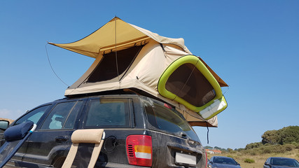 caravan tent on the top of the car by the beach