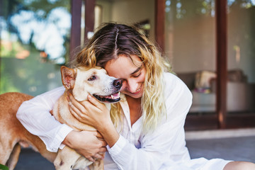 Beautiful caucasian woman hugging her mongrel dog pet - Powered by Adobe