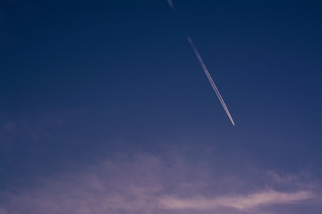 airplane flying in the sky with white clouds