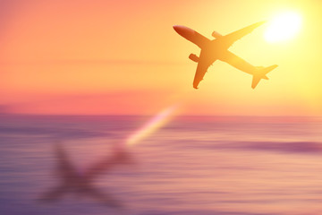 Airplane flying over tropical beach with smooth wave and sunset sky abstract background.
