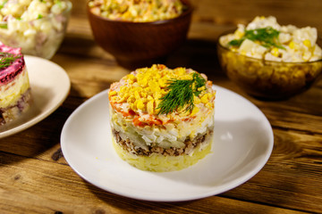 Set of festive mayonnaise salads on wooden table