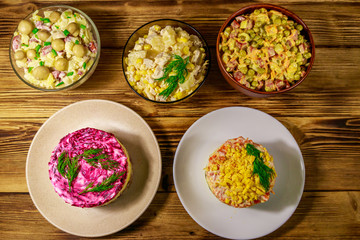Set of festive mayonnaise salads on wooden table. Top view