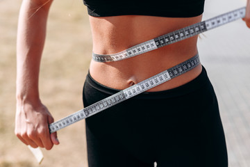 Closeup tape measure on a waist. - Concept diet and figure