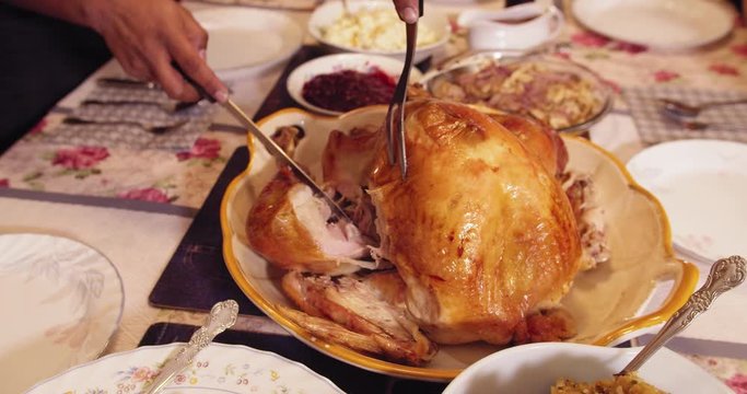 Thanksgiving turkey carving on a table: cutting the leg in slow motion 4K