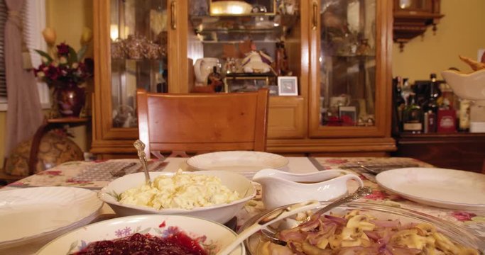 Placing a Thanksgiving turkey on a table full of food, ready for a feast in slow motion 4K