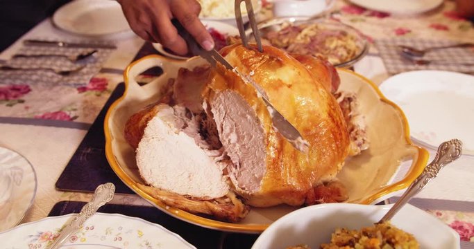 Thanksgiving turkey carving: cutting slices of tender turkey breast meat in slow motion 4K
