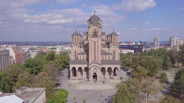 Descending 4k aerial revealing shot of St Mark Church in Tasmajdan park, Belgrade