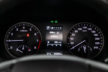 Car dashboard with white  backlight: Odometer, speedometer, tachometer, fuel level, water temperature and more.
