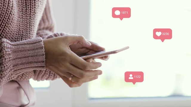 Woman blogger browsing phone, indicators with sign of likes, comments and followers over it, hands closeup. Rising datas of counters. Concept of working in social network and popularity.