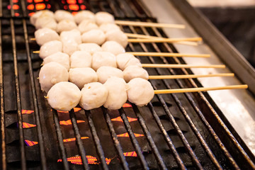 Barbecue meat balls are grilling on stove.