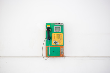 Coin-operated public payphone and white background