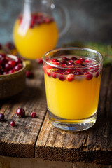 Spice fruity orange punch with cranberry in glass on wooden table