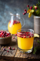 Spice fruity orange punch with cranberry in glass on wooden table