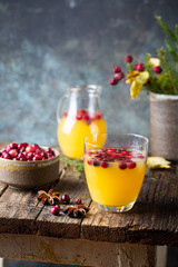 Spice fruity orange punch with cranberry in glass on wooden table