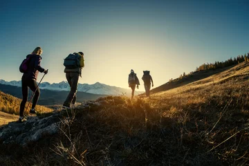 Foto op Plexiglas Group of hikers walks in mountains at sunset © cppzone