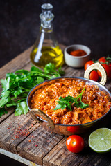 Chicken meat with tikka masala sauce, spicy curry food in iron copper pot with seasonings